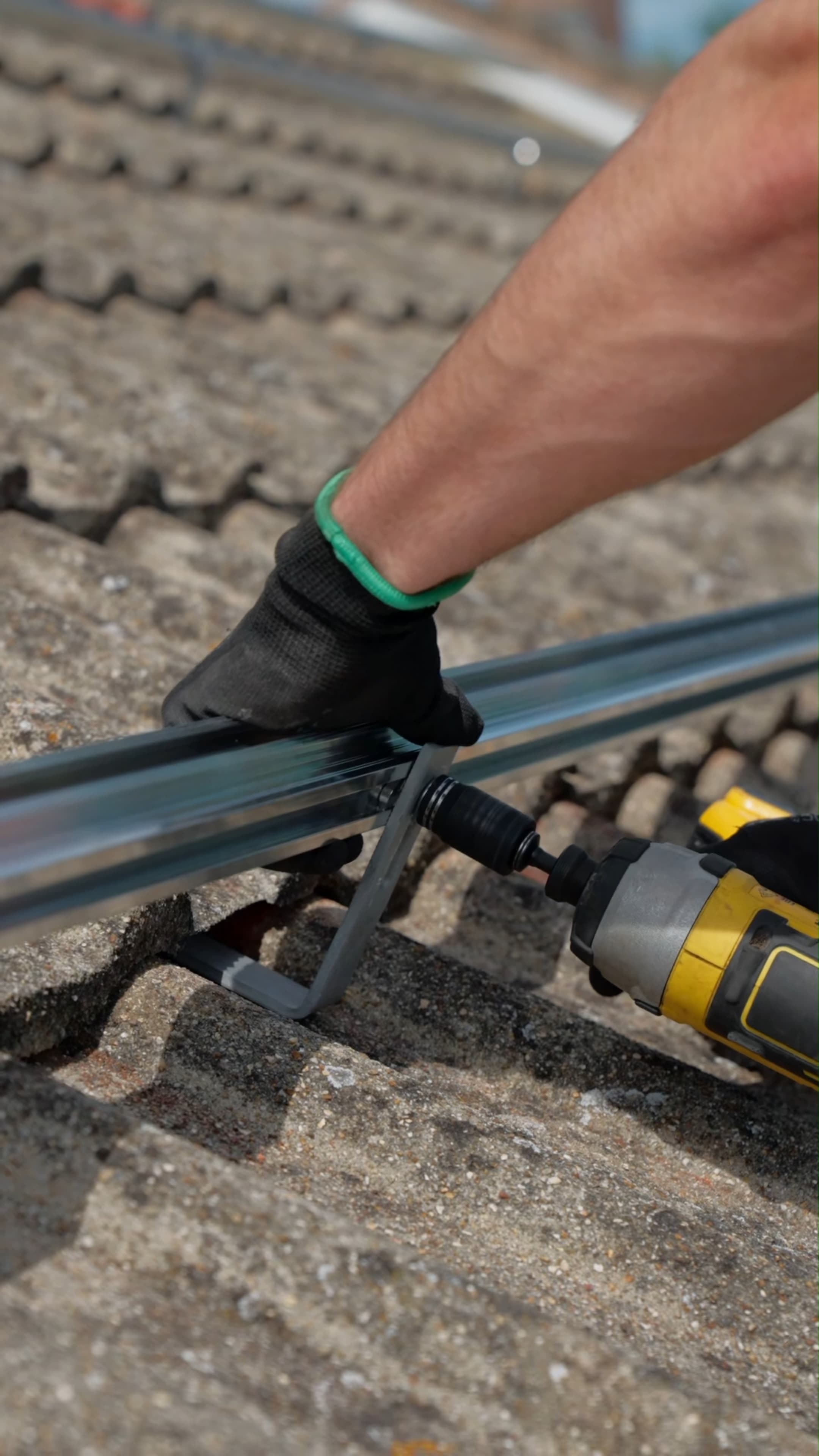 Close-up of a Geko engineer fitting a roof mounting bracket with a driver
