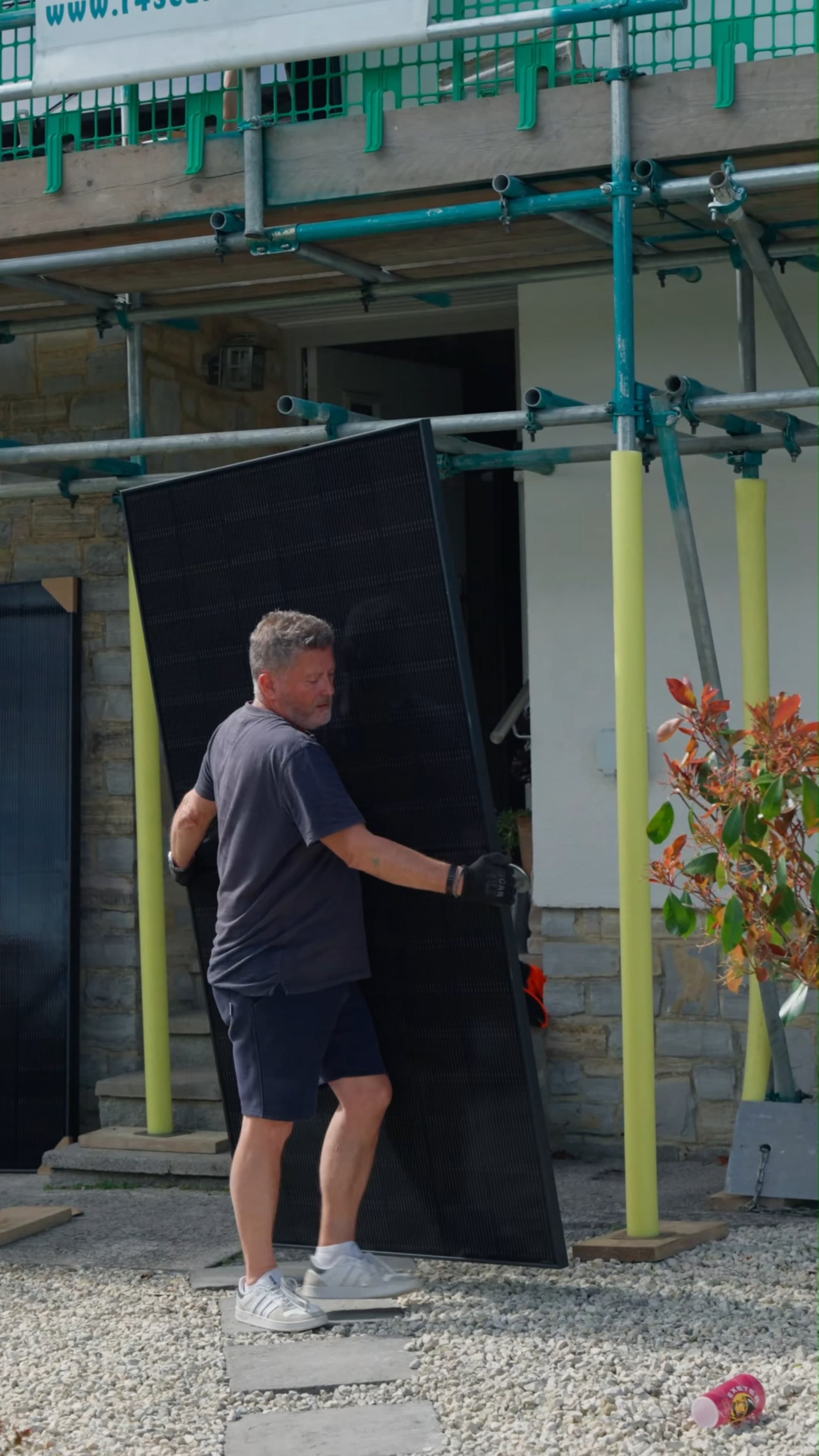 A Geko engineer carrying a panel into position for the install